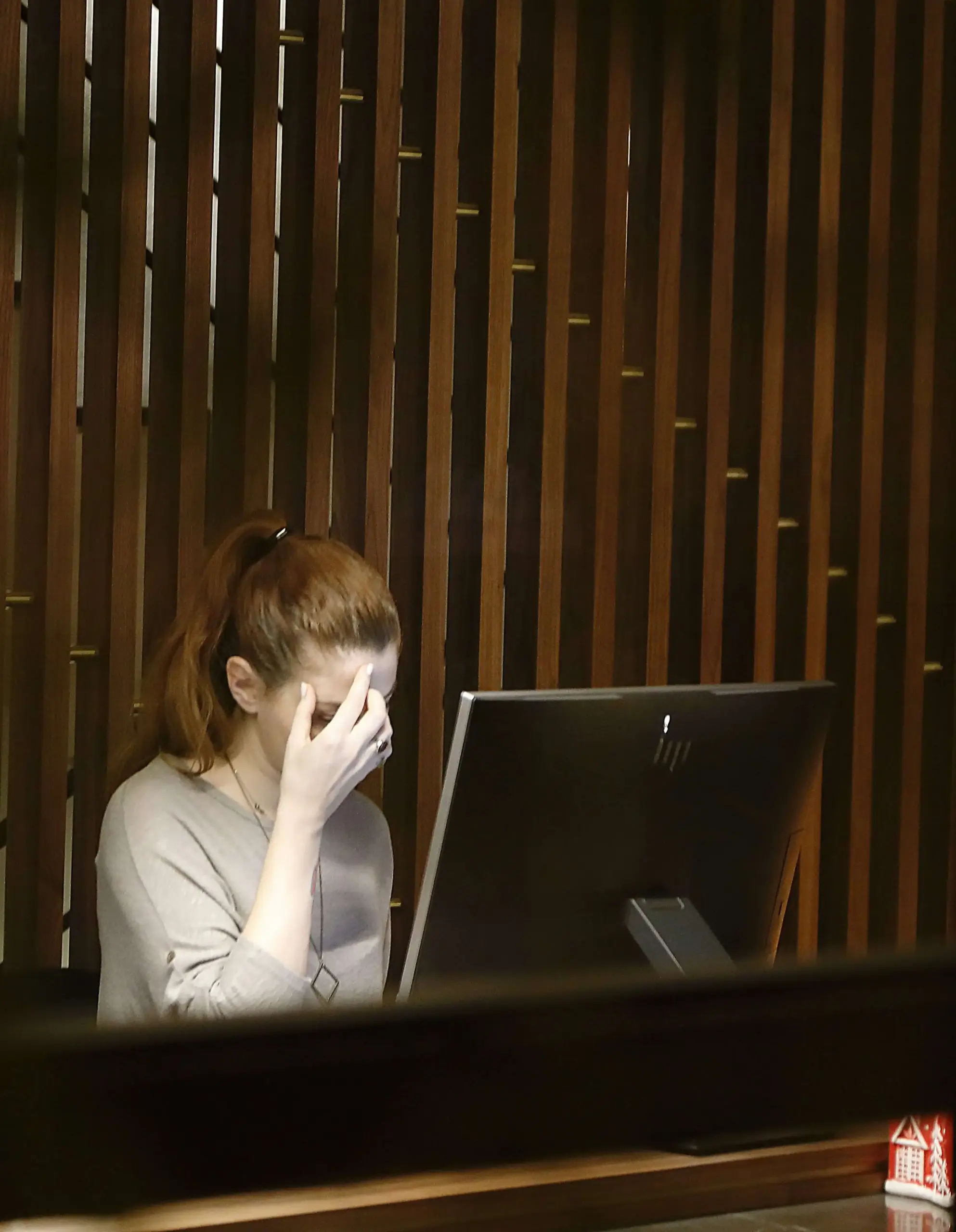 Nervous woman at grand piano, covering her face with her hand, depicting stage fright and performance anxiety